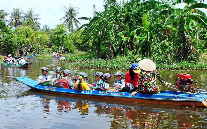 Học sinh tiểu học vùng sâu của huyện Trần Văn Thời, tỉnh Cà Mau đến trường trong năm học mới (Ảnh tư liệu năm 2018). 
