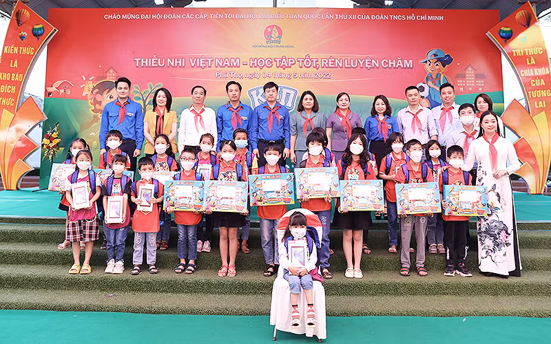 Phó Chủ tịch Thường trực Hội đồng Đội Trung ương Lê Hải Long (thứ 5 từ trái sang, hàng sau) cùng đại diện các bộ, ngành, đơn vị liên quan trao máy tính bảng, học bổng hỗ trợ học sinh có hoàn cảnh khó khăn tại Ngày hội.