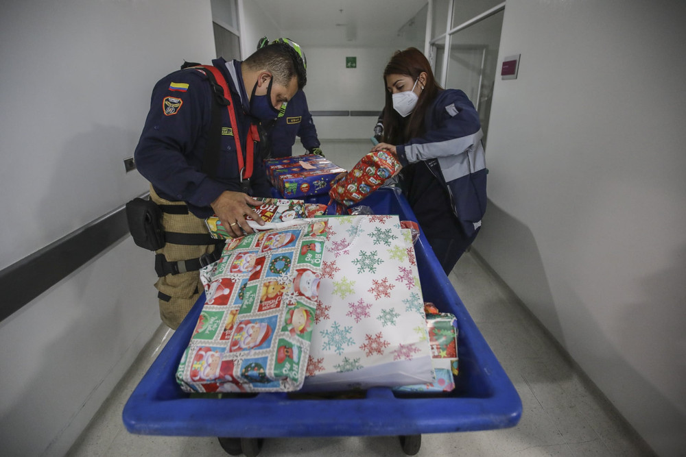 Nhân viên Sở Cứu hỏa Bogota (Colombia)) chuẩn bị quà tăng các em nhỏ tại Bệnh viện Nhi đồng La Misericordia. (Ảnh: Anadolu Agency/Getty Images) Noel -0