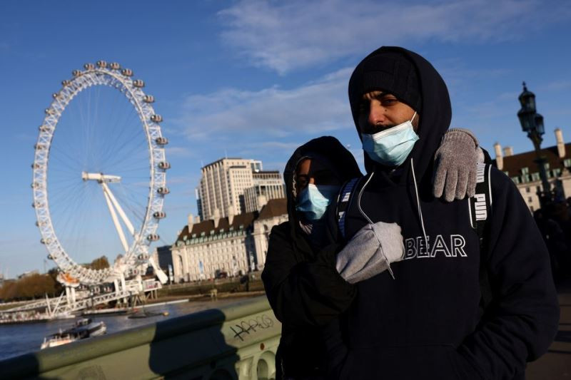 Người dân Anh đeo khẩu trang đi bộ qua cầu Westminster ở London, ngày 28/11. (Ảnh: Reuters) Tâm dịch châu Âu diễn biến phức tạp trước lo ngại về biến thể Omicron -0