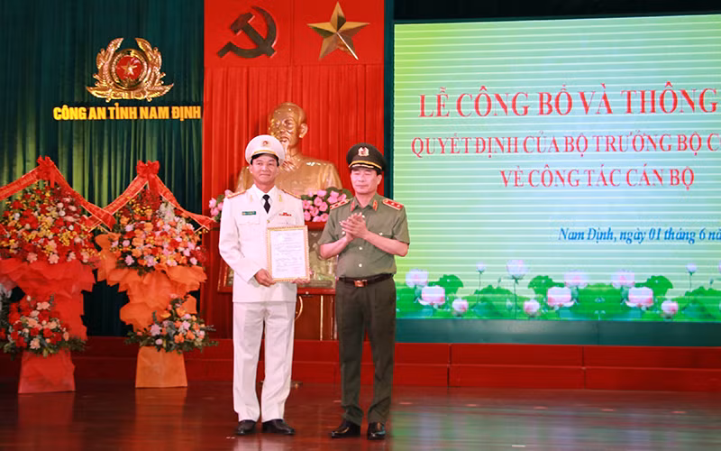 Trung tướng Lê Quốc Hùng, Thứ trưởng Công an, trao Quyết định của Bộ trưởng Công an về việc điều động, bổ nhiệm Đại tá Trần Minh Tiến giữ chức vụ Giám đốc Công an tỉnh Nam Định.