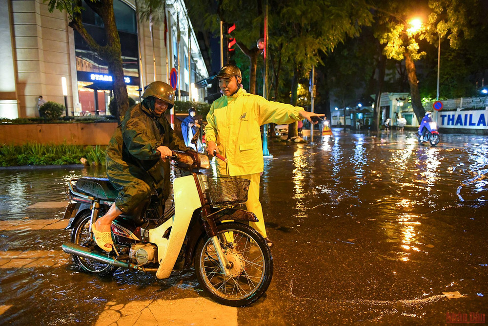 Nhân viên thoát nước Hà Nội tận tình hướng dẫn người tham gia giao thông tránh đi vào điểm ngập sâu. Những người “tháo cống” chống ngập cho Thủ đô -0