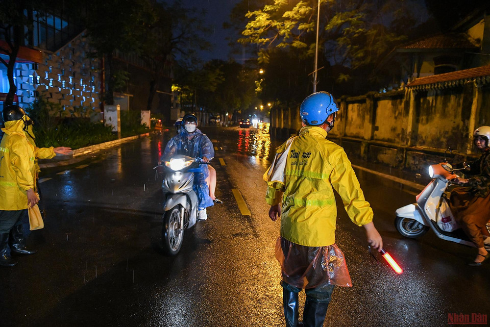 Trọng cùng các đồng nghiệp hướng dẫn người dân quay đầu tránh đi vào điểm ngập sâu. Những người “tháo cống” chống ngập cho Thủ đô -0