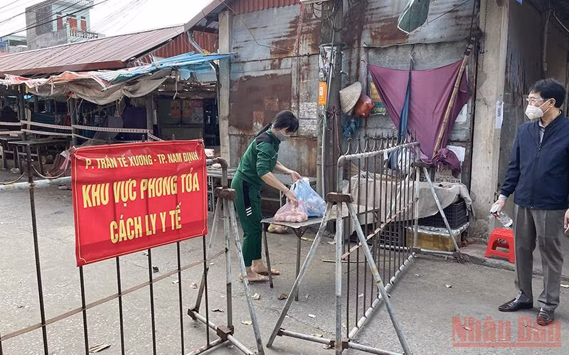 Người dân nhận nhu yếu phẩm trong khu cách ly ở chợ Phụ Long, phường Trần Tế Xương, thành phố Nam Định.