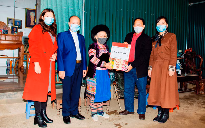 Phóng viên thường trú Báo Nhân Dân tại Lào Cai trao tặng quà Tết cho Bà mẹ Việt Nam Anh hùng Lý Seo Xay, dân tộc H’Mông, ở tổ 31, phường Bắc Cường, thành phố Lào Cai.