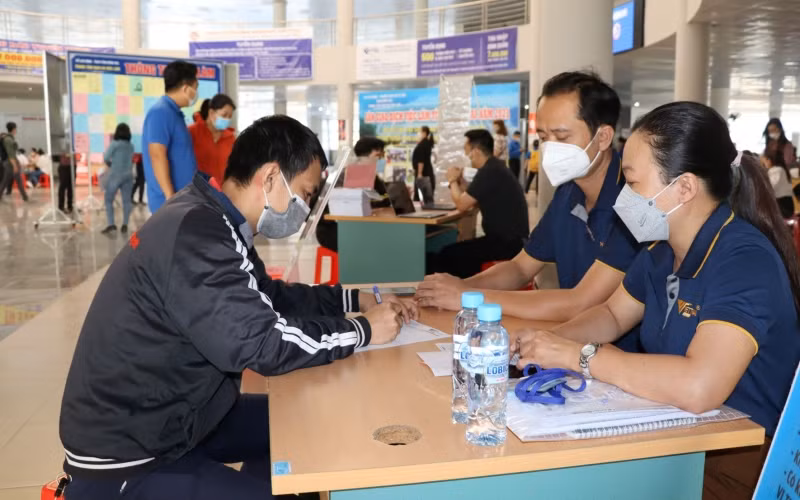 Anh Nguyễn Hoàng Hiệp (bên trái) đăng ký thông tin với nhà tuyển dụng.