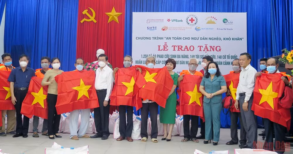 Nguyên Chủ tịch nước Trương Tấn Sang trao tặng cờ Tổ quốc và áo phao cứu sinh cho ngư dân -0