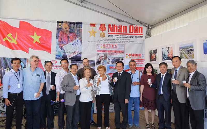 Tác giả (thứ năm từ trái sang) và một số Việt kiều vinh dự chụp ảnh cùng Đoàn đại biểu Báo Nhân Dân do Phó Tổng Biên tập Phan Huy Hiền dẫn đầu và các bạn Pháp gắn bó với Việt Nam tại Gian trưng bày Báo Nhân Dân ở Hội báo Nhân đạo tháng 9-2016. 