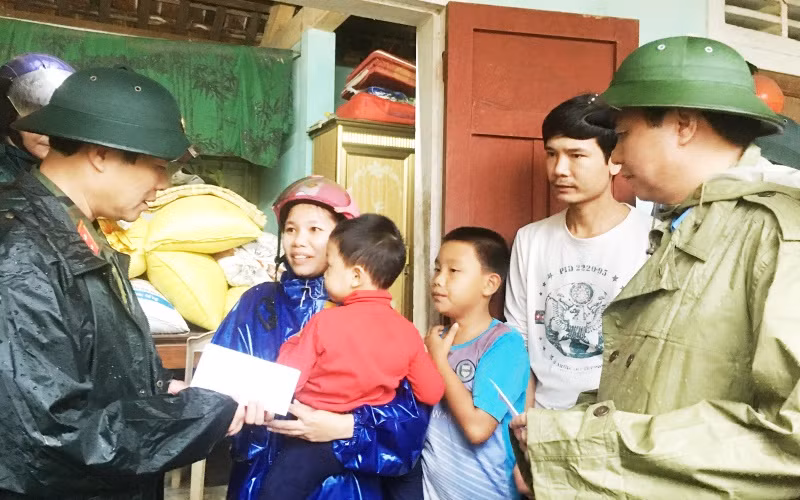 Thứ trưởng Quốc phòng Nguyễn Tân Cương (bên trái) cùng Chủ tịch UBND tỉnh Quảng Trị Võ Văn Hưng thăm, tặng quà cho hộ dân xã Triệu Thành, huyện Triệu Phong.