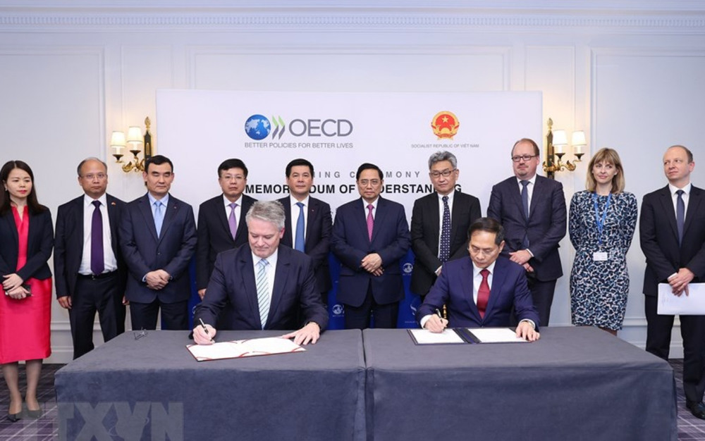Thủ tướng Phạm Minh Chính chứng kiến Bộ trưởng Ngoại giao Bùi Thanh Sơn và Tổng Thư ký OECD Mathias Cormann ký Biên bản ghi nhớ hợp tác giữa Việt Nam và OECD giai đoạn 2022-2026. (Ảnh: Dương Giang/TTXVN) ttxvn_thu_tuong_tiep_oecd3-1636155502611.jpeg
