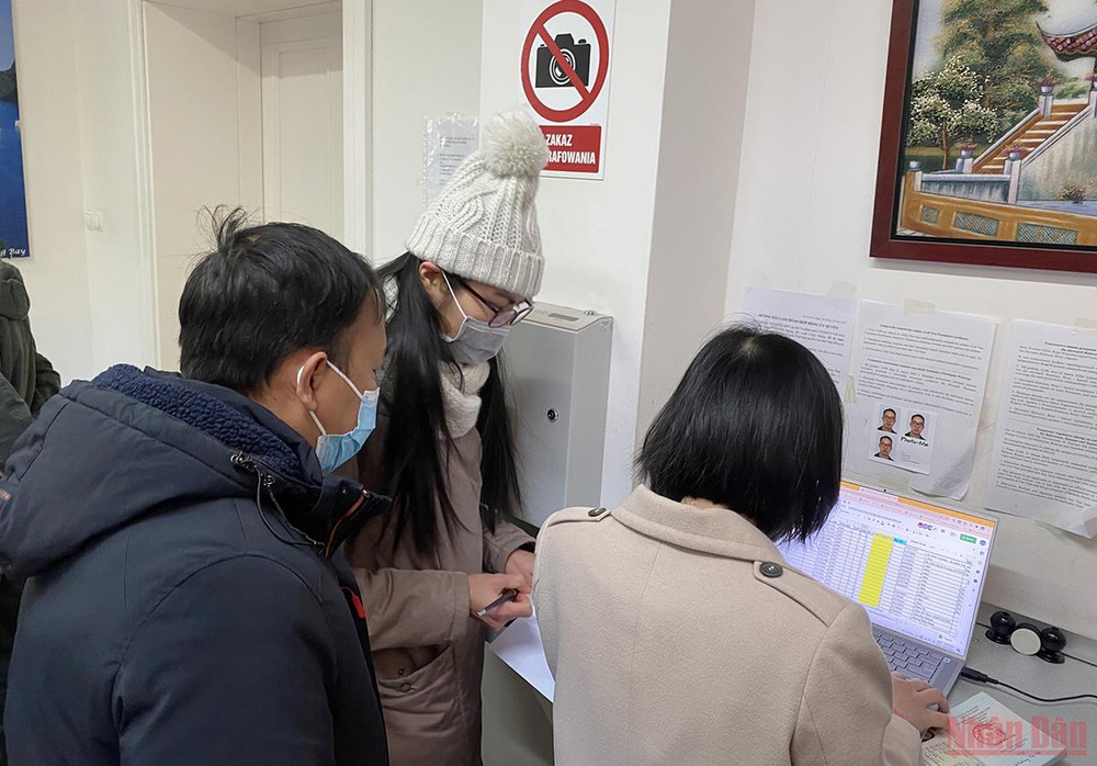 Nhân viên Đại sứ quán hỗ trợ bà con đến làm thủ tục tại Đại sứ quán Việt Nam ở Ba Lan cho chuyến bay hồi hương thứ 2 do Vietnam Airlines thực hiện vào ngày 12/3. (Ảnh: KHẢI HOÀN) Ngày 12/3 có chuyến bay hồi hương thứ hai từ Ba Lan -0