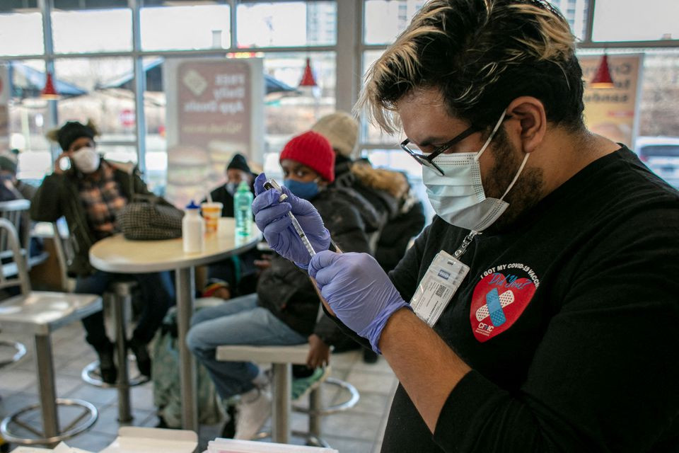 Nhân viên y tế chuẩn bị 1 liều vaccine tăng cường ở Chicago, Illinois, Mỹ, ngày 21/12/2021. (Ảnh: REUTERS) Hồng Kông (Trung Quốc) tăng cường các cơ sở cách ly ứng phó đợt bùng phát dịch mới -0