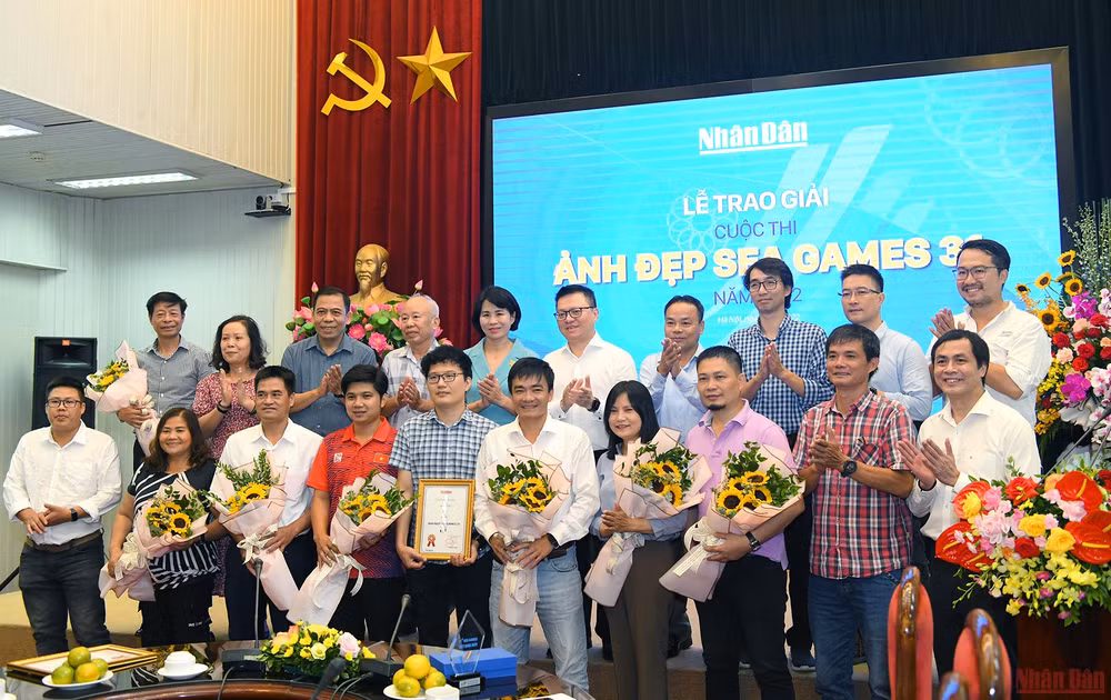 Tổng Biên tập Báo Nhân Dân Lê Quốc Minh và các đại biểu chụp ảnh lưu niệm cùng các tác giả đoạt giải cuộc thi “Ảnh đẹp SEA Games 31”.