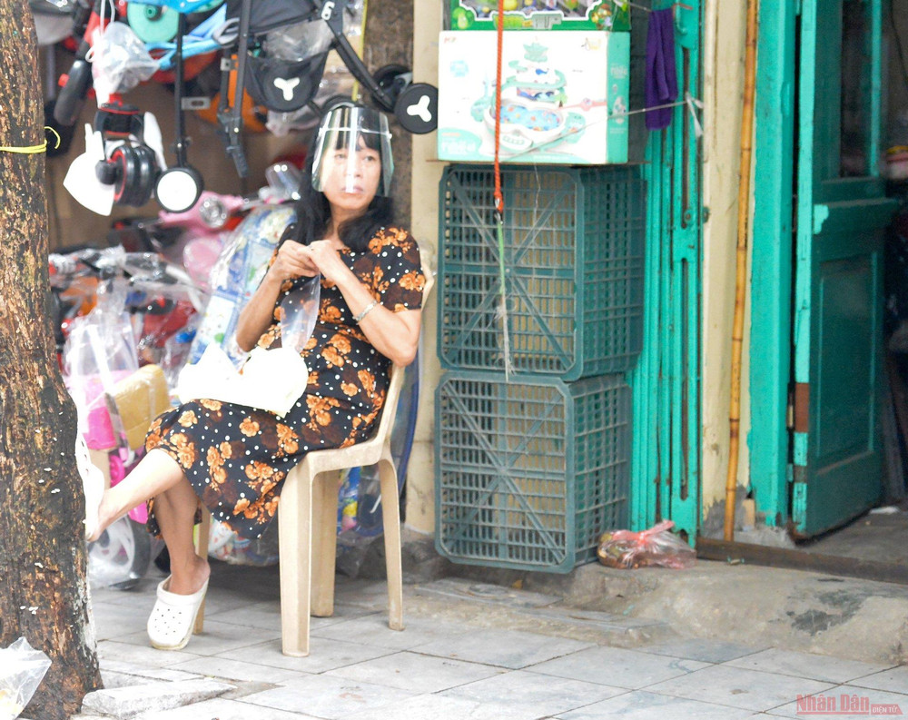 Tại một số cửa hàng bán đồ gia dụng trên phố Hàng Bông, các chủ cửa hàng đã chủ động đeo kính chống giọt bắn để phòng dịch. Hàng quán Hà Nội dựng vách ngăn phòng Covid-19 -0