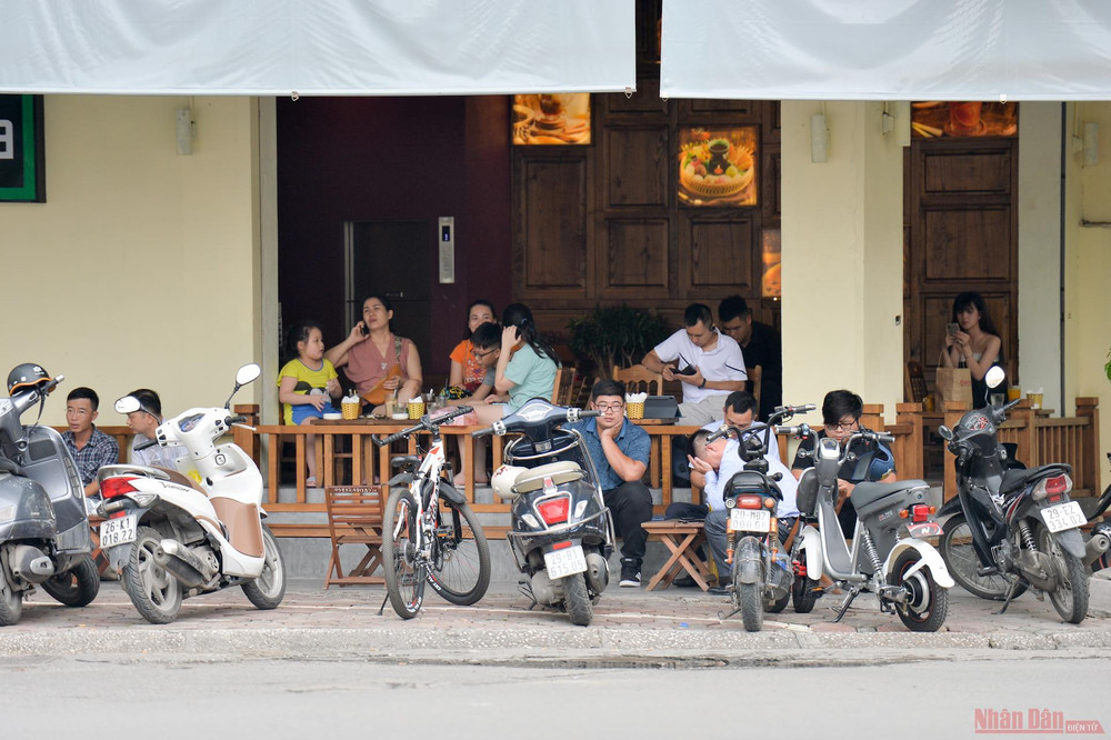Tuy nhiên, cũng có nhiều hàng quán không chấp hàng việc nhắc nhở khách hàng giãn cách. Hình ảnh ghi lại tại một quán cà phê trên phố Hàng Bài. Hàng quán Hà Nội dựng vách ngăn phòng Covid-19 -0