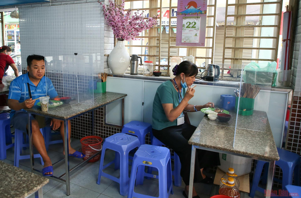 Tất cả người đến dùng bữa đều được hướng dẫn ngồi đúng vị trí quy định và dùng bữa qua các vách ngăn. Hàng quán Hà Nội dựng vách ngăn phòng Covid-19 -0