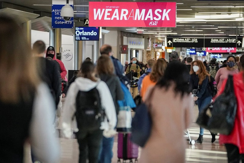 Hành khách đeo khẩu trang di chuyển trong sân bay Quốc tế Hartsfield-Jackson Atlanta ở Atlanta, Georgia, Mỹ, ngày 22/12/2021. (Ảnh: REUTERS) Thế giới ghi nhận trên 9,4 triệu ca nhiễm Covid-19 trong tuần cuối cùng năm 2021 -0
