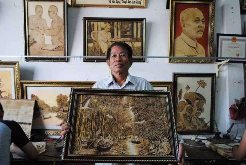 Ông Tạng với bức tranh “Rừng tràm ở An Giang”. Nghệ nhân vẽ tranh từ lá thốt nốt, vỏ trấu -0