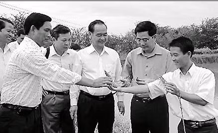 Anh Xuân (ngoài cùng, bên phải) giới thiệu mô hình nuôi tôm sú cho hiệu quả kinh tế cao.