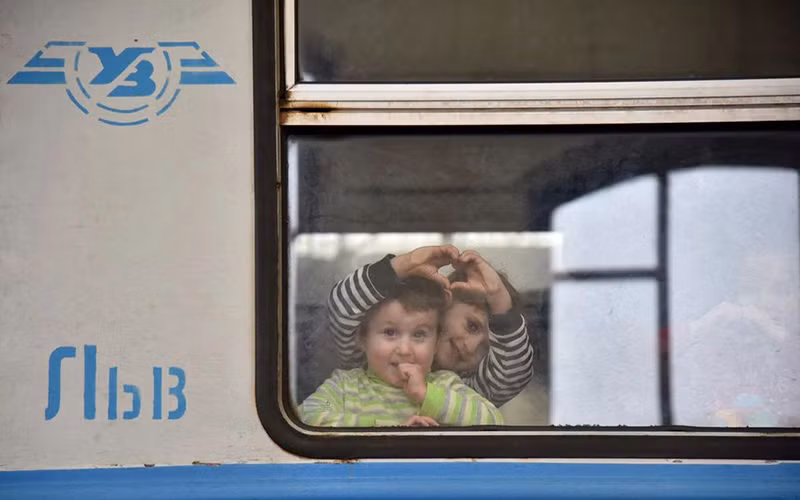 Những trẻ em được sơ tản nhìn ra cửa sổ toa tàu tại một nhà ga ở Lvov, Ukraine, ngày 9/3/2022. (Ảnh: REUTERS)