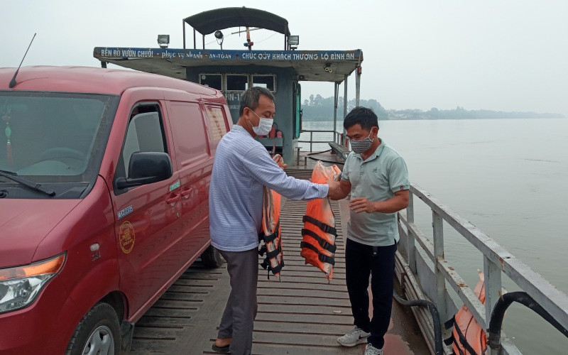 Phát áo phao cho khách tại bến đò Vườn Chuối. Hà Nội tăng cường phòng, chống dịch tại các bến đò, bến phà -0