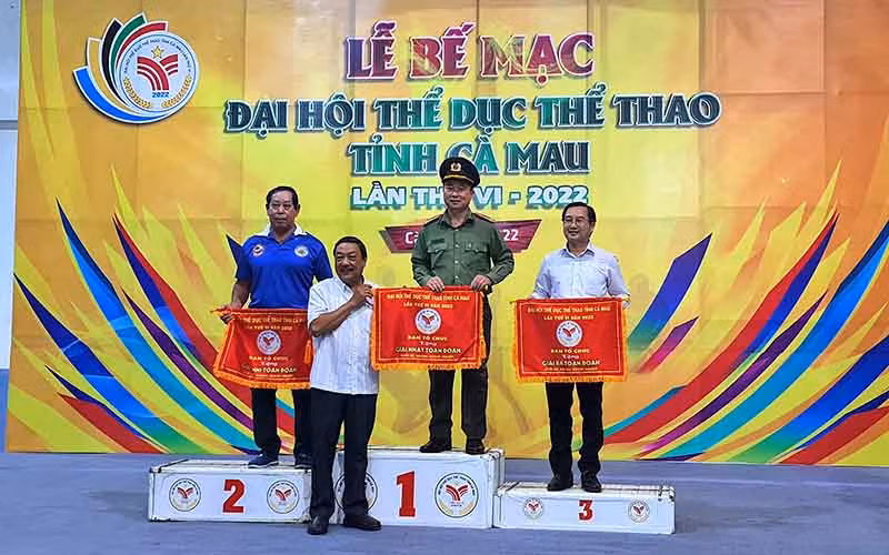 Đại diện Ban Tổ chức trao cờ thi đua cho các đơn vị đạt thành tích cao toàn đoàn tại Đại hội Thể dục Thể thao tỉnh Cà Mau.