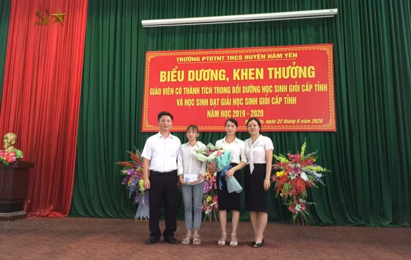 Lê Vân Anh trong vòng tay yêu thương của thầy, cô nhà trường. (Ảnh do BGH Trường THCS nội trú Hàm Yên cung cấp)