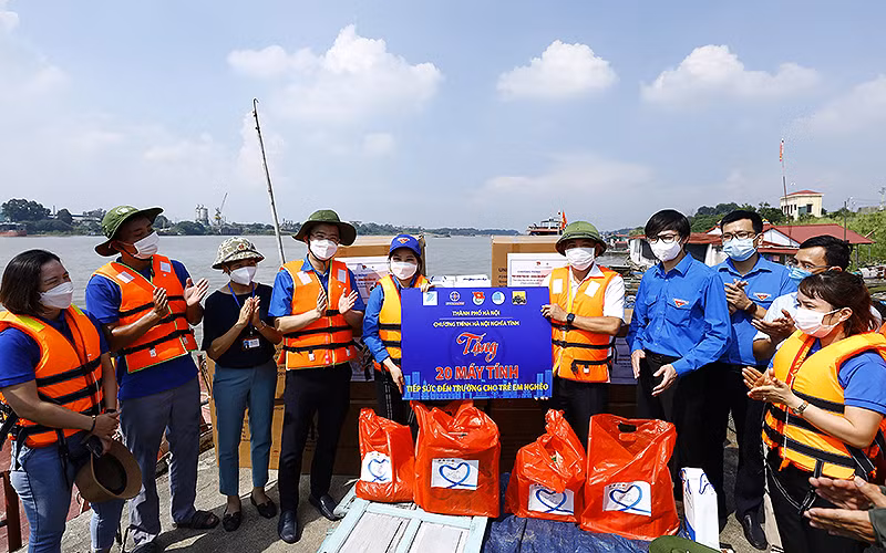 Đại diện các đơn vị, nhà tài trợ bàn giao máy tính/máy tính bảng để vận chuyển đến trao tận tay thiếu nhi ở làng chài ven sông Hồng.