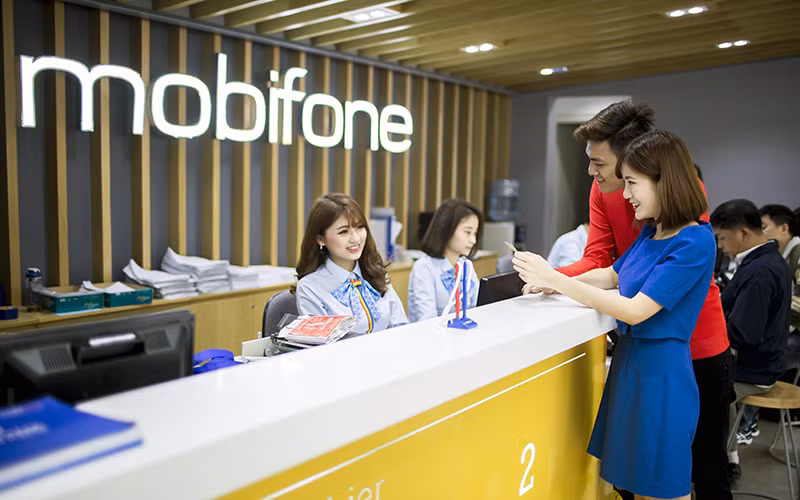 Khách hàng làm thủ tục giao dịch tại cửa hàng của Mobifone. (Ảnh TUẤN TÚ) 