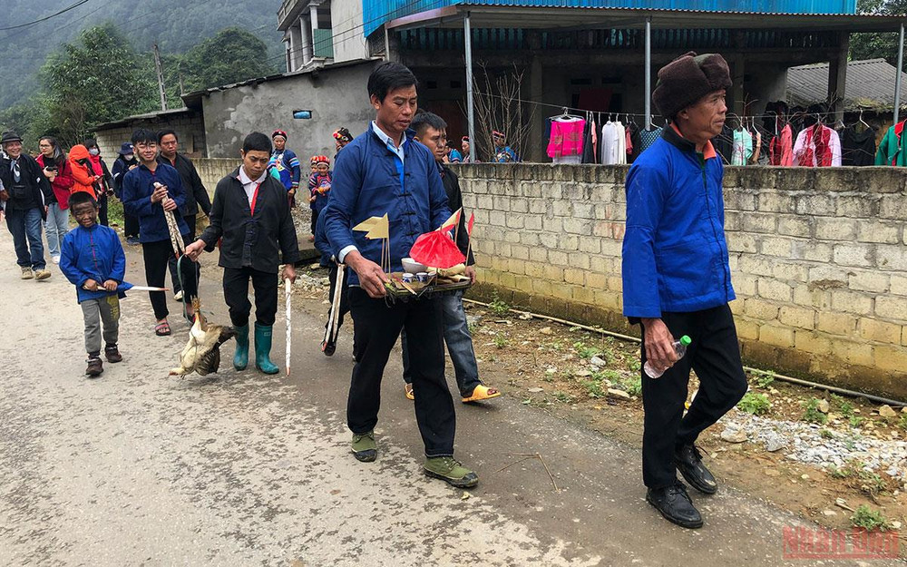 Đoàn lễ đang đi đến từng nhà để thực hiện lễ quét ma.