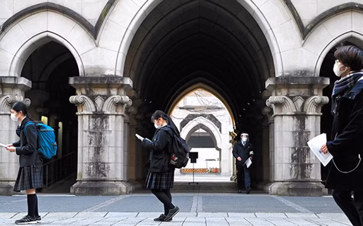 Các thí sinh thi đại học giữ khoảng cách trong khi chờ kiểm tra sơ bộ đầu vào tại Tokyo, Nhật Bản. Ảnh: The Asahi Shimbun
