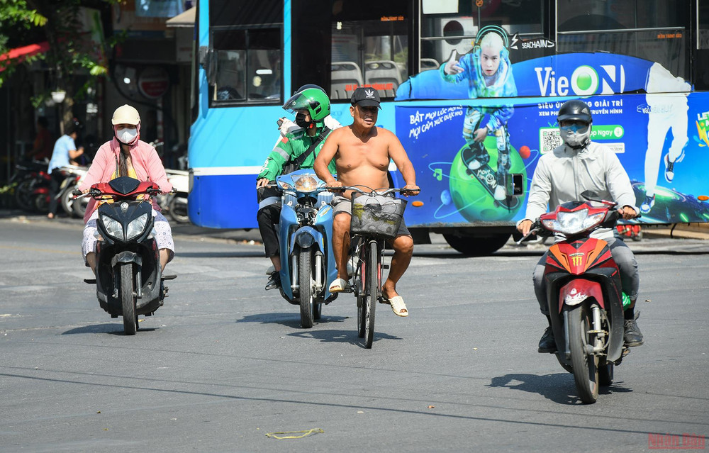 Một số người không chịu nổi cái nóng oi bức khi ra đường. Người dân Hà Nội chống chọi với nắng nóng gay gắt -0