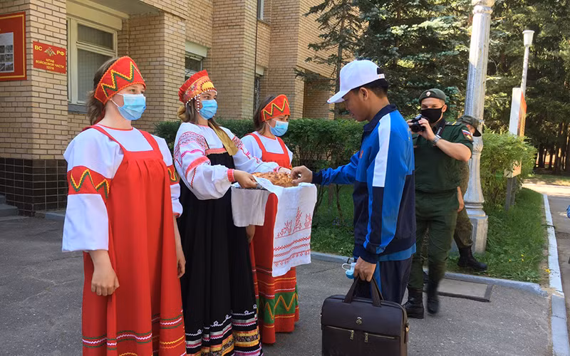 Thành viên Đội tuyển Huấn luyện chó nghiệp vụ được mời nếm bánh mỳ chấm muối, nghi thức tiếp đón truyền thống của phía bạn. Ảnh: NGỌC SÁNG