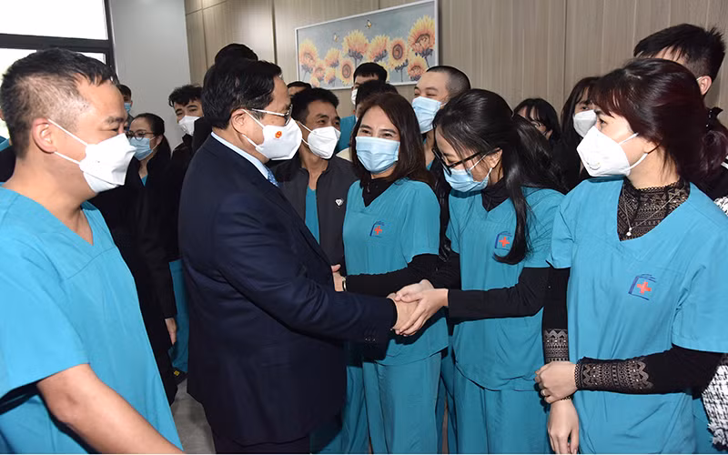 Thủ tướng Phạm Minh Chính tới thăm, chúc Tết đội ngũ bác sĩ, y tá, nhân viên y tế đang làm nhiệm vụ tại Bệnh viện điều trị bệnh nhân Covid-19 của Bệnh viện Đại học Y Hà Nội, đặt tại quận Hoàng Mai.