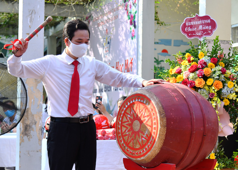 Thầy giáo Phạm Văn Hoan, Hiệu trưởng trường PTCS Xã Đàn, đánh trống khai giảng năm học mới 2020-2021. Sau lễ khai giảng, học sinh lên lớp học tiết đầu tiên về giáo dục nếp sống văn minh, nội quy và công tác phòng, chống dịch bệnh. Ngày khai giảng của những học sinh “đặc biệt” -5