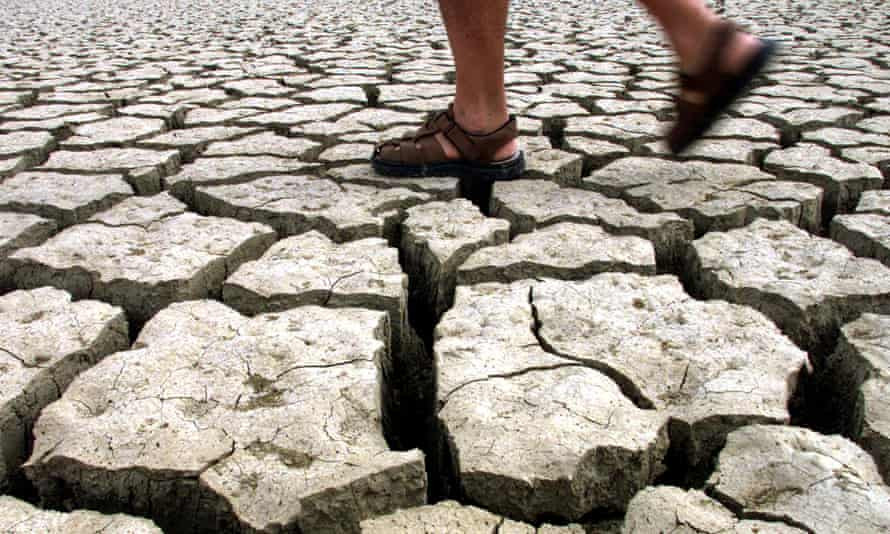 Một người đàn ông đi bộ qua hồ Jato khô cạn ở Italy. Ảnh: Reuters.