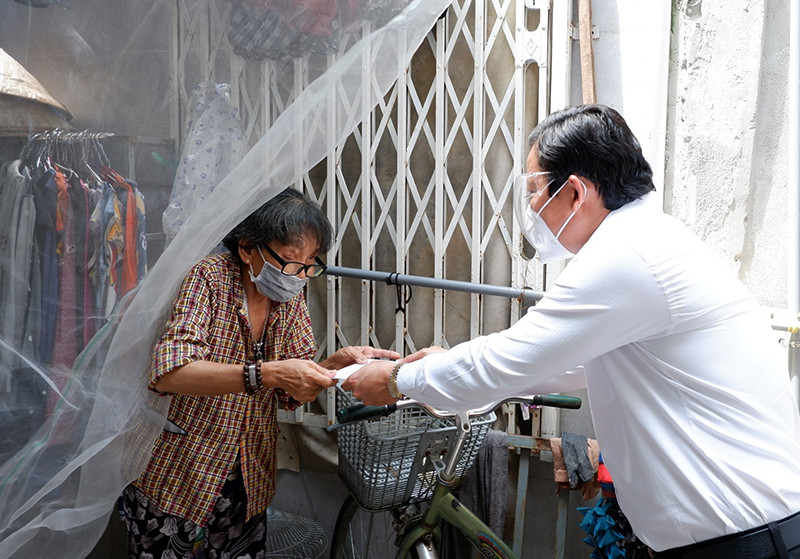 Lãnh đạo Ủy ban nhân dân tỉnh Long An trao tiền hỗ trợ cho người dân bán vé số lẻ do ảnh hưởng của dịch Covid-19 tại huyện Cần Giuộc, tỉnh Long An. 70 tỷ đồng hỗ trợ 42.550 người dân bị ảnh hưởng của dịch Covid-19 tại Long An -0