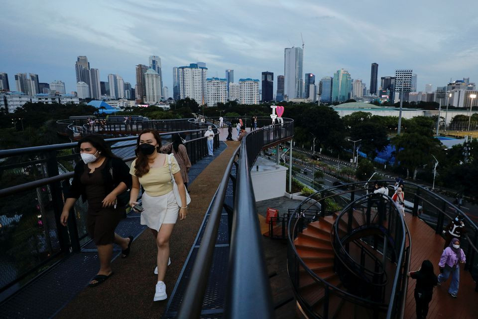 Người dân đeo khẩu trang đi dạo trên cầu đi bộ ở Jakarta, Indonesia, ngày 7/2/2022. (Ảnh: REUTERS) Hàn Quốc ghi nhận trên 240 nghìn ca mắc Covid-19 trong 3 ngày liên tiếp -0