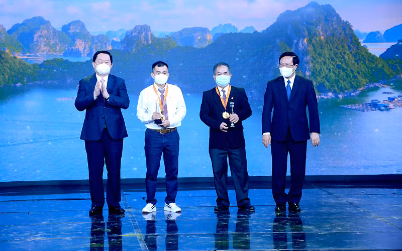 Các đồng chí Phạm Bình Minh, Nguyễn Trọng Nghĩa trao giải Nhất cho các tác giả.