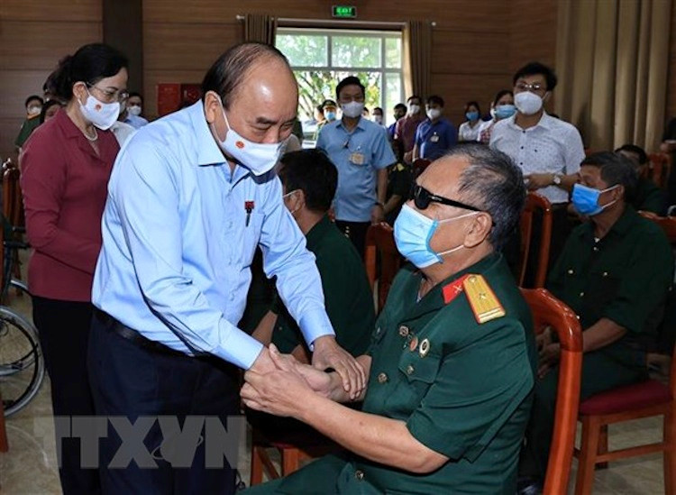 Chủ tịch nước Nguyễn Xuân Phúc đến thăm hỏi, tặng quà các thương bệnh binh tại Trung tâm Nuôi dưỡng thương bệnh binh nặng và điều dưỡng người có công tỉnh Hà Nam. (Ảnh: TTXVN)