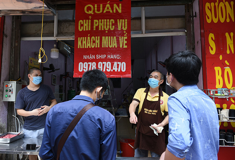 Khách mua cơm trên phố Nguyễn Trường Tộ (Ba Đình). Chủ cửa hàng cho biết, trong thời gian ngắn từ khi mở cửa nhân viên trong quán đã làm việc liên tục để phục vụ các đơn hàng. “Vùng xanh” Hà Nội trong ngày đầu cơ sở kinh doanh mở cửa trở lại -0