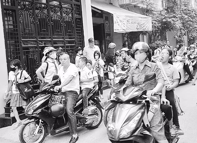 Nhiều cha mẹ học sinh vẫn thờ ơ trong việc đội mũ bảo hiểm cho chính bản thân và con mình.