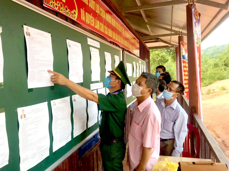 Bộ đội biên phòng và bà con ở xã Thượng Trạch tìm hiểu các ứng cử viên trước khi ghi phiếu bầu. Rộn ràng ngày hội ở vùng sâu, vùng xa Quảng Bình -0