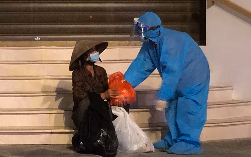 Tình nguyện viên “Bữa cơm nghĩa tình - Vượt qua đại dịch” mang thực phẩm đến hỗ trợ người có hoàn cảnh khó khăn trong đêm.