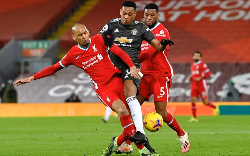 Martial (áo sẫm, Man United) bị “kẹp” giữa Fabinho (trái) và Wijnaldum trong lần gặp Liverpool trên sân Anfield.	