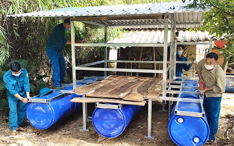 Dân quân xã Điền Mỹ, huyện Hương Khê, tỉnh Hà Tĩnh giúp người dân làm nhà nổi chống lũ. (Ảnh HUY CƯỜNG)