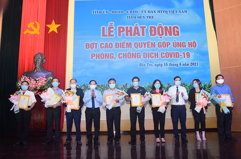 Chủ tịch Ủy ban nhân dân tỉnh Bến Tre trao hoa, thư cảm ơn cho các nhà tài trợ.