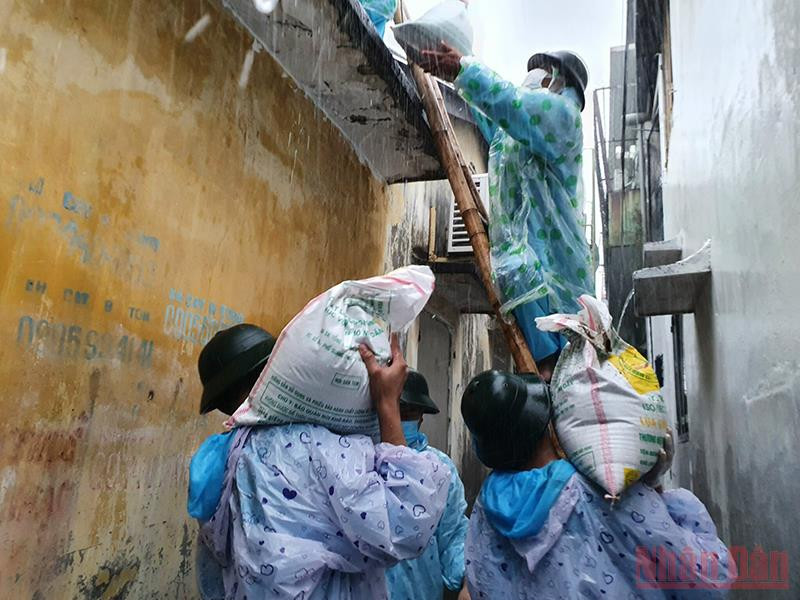 Các cán bộ chiến sĩ giúp dân tại khu vực phong tỏa cứng phường Tam Thuận, quận Thanh Khê. Hàng chục cán bộ chiến sĩ chằng chống nhà giúp dân khu vực phong tỏa cứng -0