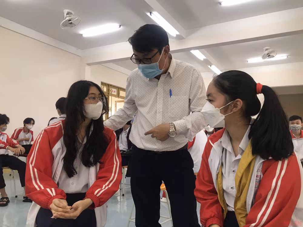 Thầy Lê Đắc Tường hỏi thăm sức khỏe các em học sinh sau khi tiêm vaccine Covid-19.