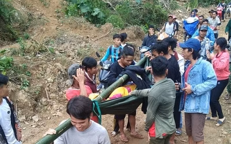 Người làng ở thôn Tre, xã Trà Tây gánh người bệnh ra đường lớn đón xe cấp cứu.